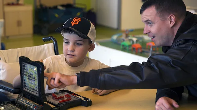 Wikimedia Commons / U.S. Navy Capt. plays the board game Battleship with a patient at Children’s Hospital. (30116294906)